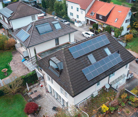 Luftaufnahme von Häusern mit Sonnenkollektoren auf den Dächern in einem Vorort. - © Bild: Daikin © Bild: Daikin